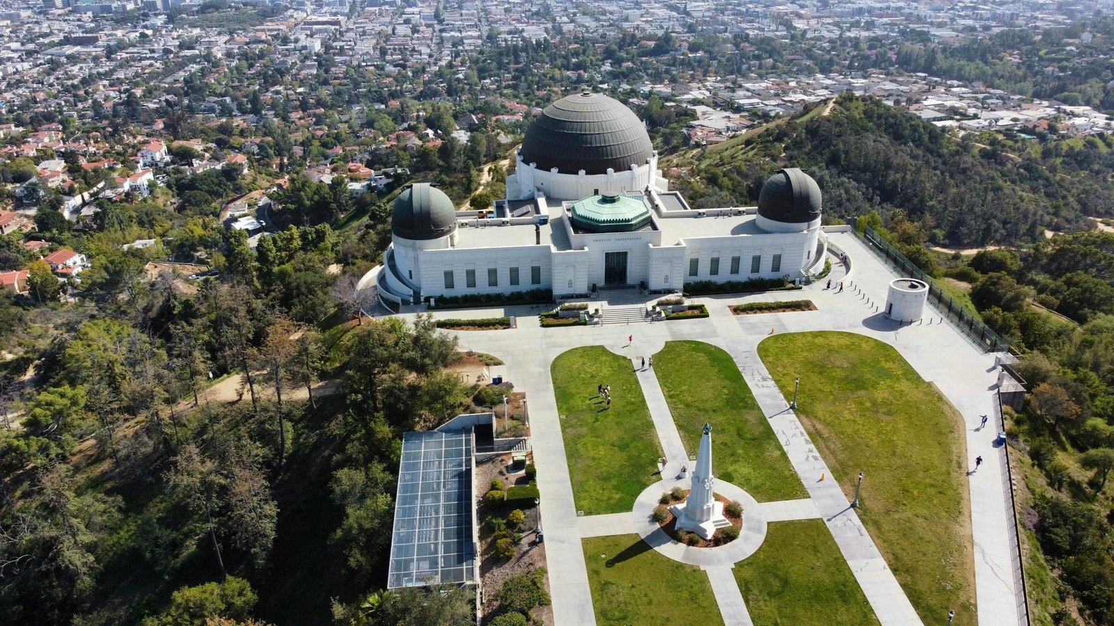 A stunning aerial shot of Griffith Observatory overlooking Los Angeles cityscape and greenery.