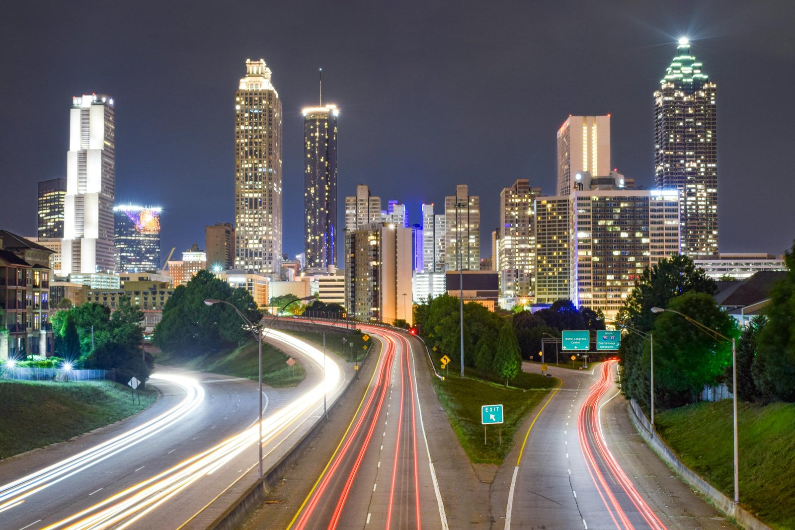 Vibrant night view of Atlanta city skyline with light trails highlighting urban motion.