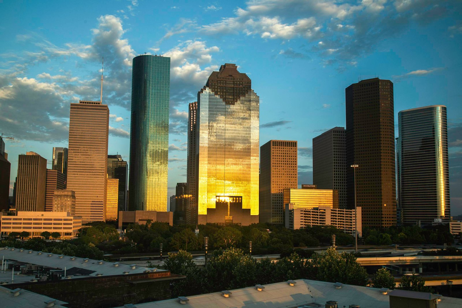View of Houston's downtown skyline with a beautiful sunset reflection on skyscrapers.